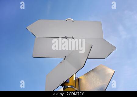 Empty metal tables shaped like arrows against blue sky - add your text Stock Photo