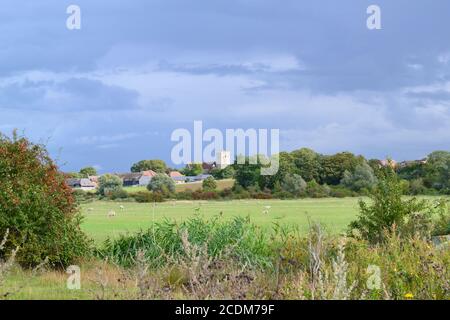 Distant St Helen's church seen from the north Kent marshes near Cliffe on the Hoo peninsula on a stormy August day. Stock Photo