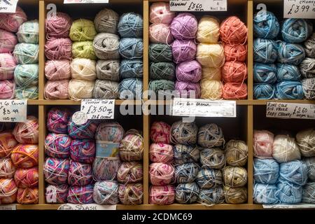 Balls of coloured knitting wool arranged on shelve on sale in a shop. Stock Photo