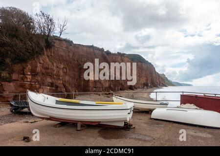 Boats on the quayside in front of red sandstone cliffs at Sidmouth in South Devon, UK Stock Photo