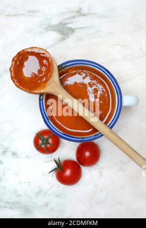 Cup with tomato soup and cooking spoon, Germany Stock Photo