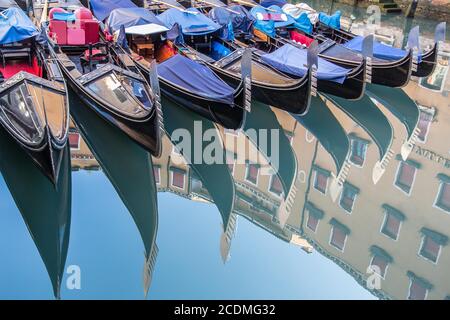 Venetian gondolas reflected in the water, Bacino Orseolo, near St Mark's Square, Venice, Italy Stock Photo