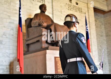 An honor guard in full ceremonial uniform stands beside the bronze statue of Chiang Kai-shek in Taipei Stock Photo