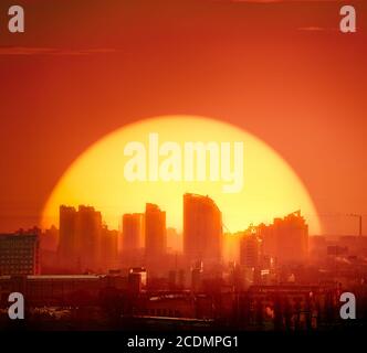 Sunset Kyiv town silhouette skyscrapers, buildings, homes. Red tones background sky with big golden sun set at European capital urban illustration architecture. Metropolis of Ukraine panorama shot Stock Photo