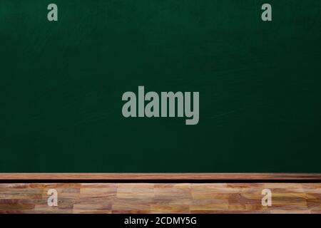 Education concept showing empty classroom chalkboard and wooden table with copy space. Stock Photo