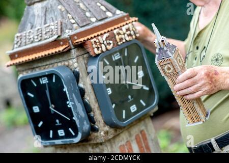 Wedemark, Germany. 21st Aug, 2020. Model maker Albert Diekmann stands next to a replica of the London Clock Tower, often referred to as Big Ben, in his front garden in the Abbensen district. Diekmann has already copied numerous sightseeings for his garden, thereunder also the Eiffel Tower and the castle Neuschwanstein. (to dpa 'Eiffel Tower, Capitol and Neuschwanstein in the front garden' from 29.08.2020) Credit: Hauke-Christian Dittrich/dpa/Alamy Live News Stock Photo