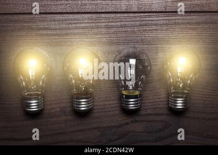 glowing bulbs weak link concept on wooden background Stock Photo