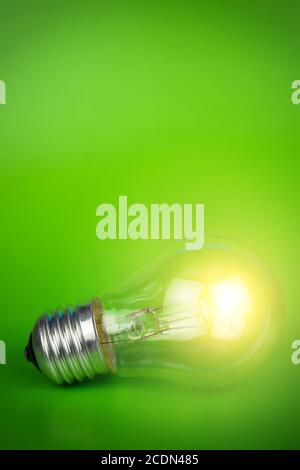 glowing light bulb over green background Stock Photo