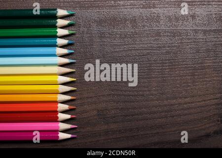 multicolored pencils on the brown wooden table background Stock Photo