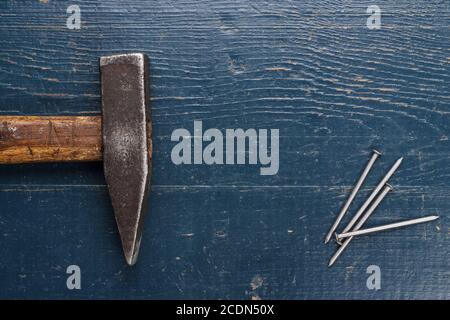 old hammer and nails on blue table Stock Photo