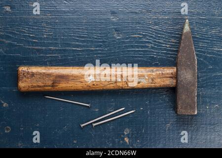 old hammer and nails on blue table Stock Photo
