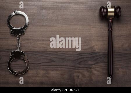 handcuffs and judge gavel on wooden background Stock Photo