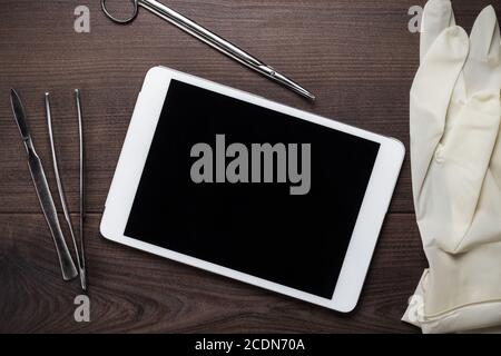 table with tablet computer tools and gloves on it Stock Photo
