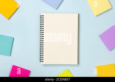 Spiral Notebook or Spring Notebook in Unlined Type and Multi Color Sticky Note on Blue Pastel Minimalist Background. Spiral Notebook Mockup on Center Stock Photo