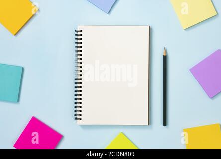 Spiral Notebook or Spring Notebook in Unlined Type and Multi Color Sticky Note and Pencil on Blue Pastel Minimalist Background. Spiral Notebook Mockup Stock Photo