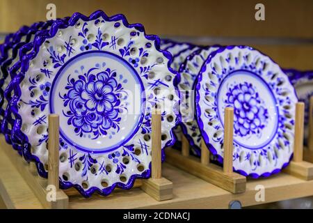 Porto, Portugal - May 29, 2018: Detail of traditional white and blue ornate azulejo Portuguese ceramic plates on display at a souvenir shop