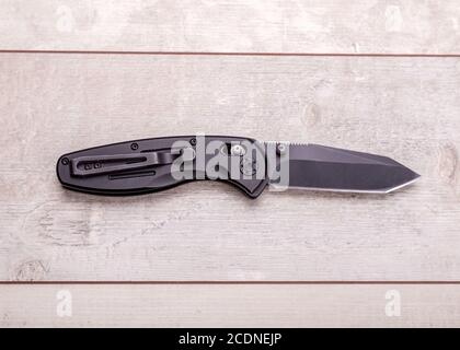 Folding knife on a wooden background Stock Photo