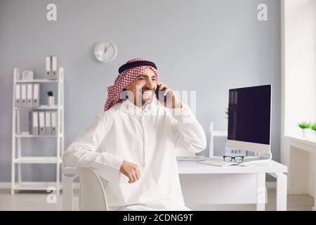 Arab man talking on a cell phone in the office. Stock Photo