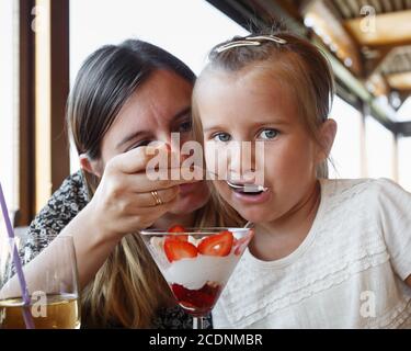 Mom feeds daughter ice cream Stock Photo