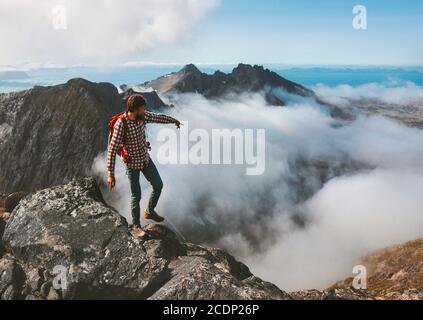 Man traveling hiking in mountains outdoor activity adventure vacations healthy lifestyle hiker guide on summit above clouds hand showing direction loc Stock Photo