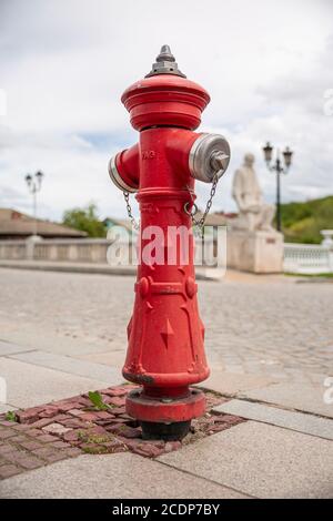 Single red fire hydrant standing on the pavement. Fire hidrant for emergency fire access . Stock Photo