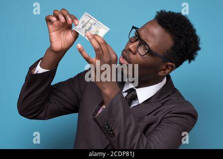 businessman in suit and glasses standing, holding money checking it on fake Stock Photo
