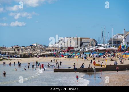 Lyme Regis, Dorset, UK. 29th Aug, 2020. UK Weather: Holidaymakers and families flock to the beach at the seaside resort of Lyme Regis to enjoy the the last of the summer holidays on a blustery day with hot sunny spells. Credit: Celia McMahon/Alamy Live News Stock Photo