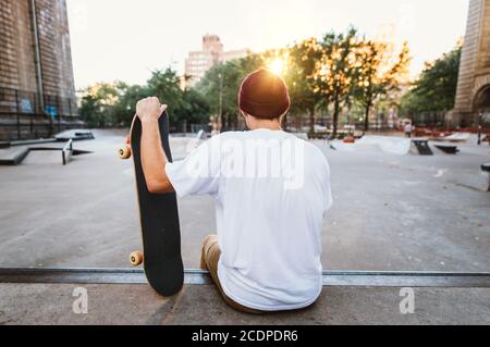 Young boy performing tricks with the skateboard in a skate park Stock Photo