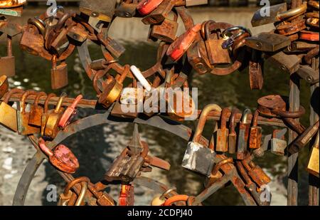 Many rusty locks on the railings of a bridge Stock Photo