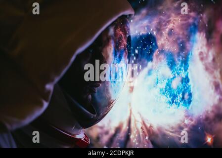 Astronaut looking deep space, galaxy and planets from the window of his capsule. Concept about science and space exploration Stock Photo