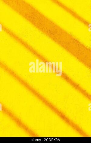 Orange diagonal stripes on yellow colored background, all appears slightly blurred and textured Stock Photo