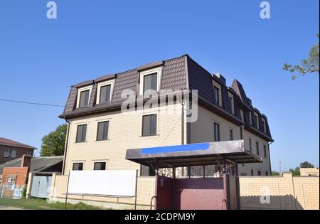 The house with plastic windows and a roof of corrugated sheet Stock Photo