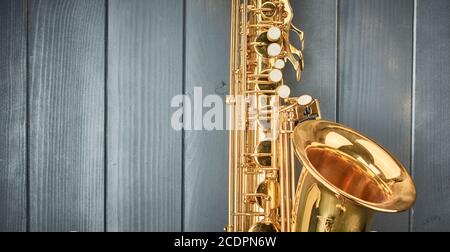 Note keys and bell of a shiny golden tenor saxophone on gray wood Stock Photo