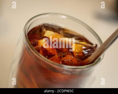 Close up of a glass of lemon tea with ice and a metal straw Stock Photo