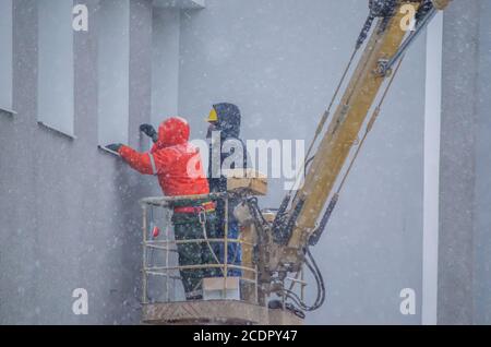 Workers on a crane carry out repair work in the winter Stock Photo