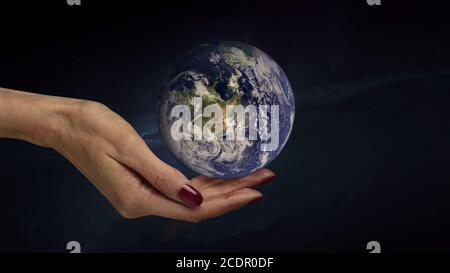 A female hand holds the planet Earth. Close-up. Space background Stock Photo