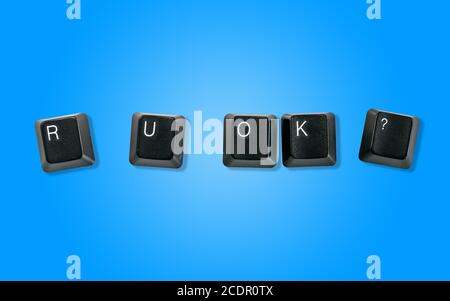 Computer keyboard keys spelling R U OK?, isolated on a blue background Stock Photo