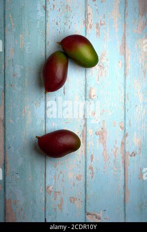 set of mangoes, cut and uncut, on a light blue background of deteriorated wood Stock Photo
