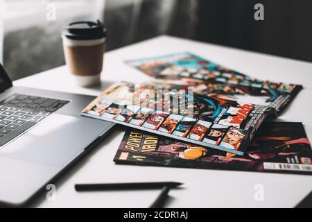 Comic books on the white table with laptop and cup of coffee. Home leisure Stock Photo