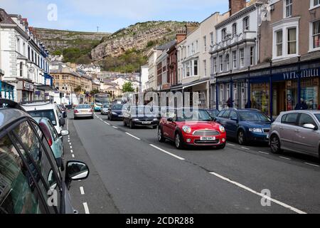 Traffic and pedestrians in Mostyn Street Llandudno, North Wales with the Great Orme headland in the background Stock Photo