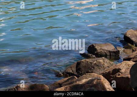 ripples on seawater and rocks at the side Stock Photo