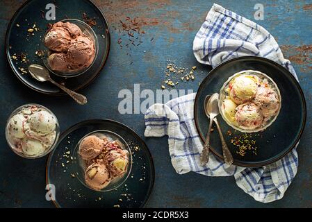 Variety of Ice cream scoops with chocolate, stracciatella, berry and vanilla flavors, scooped in to bowls Stock Photo
