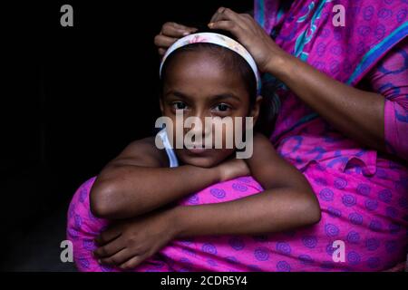 Dhaka, Dhaka, Bangladesh. 29th Aug, 2020. A young girl poses for a photo while her mother preparing her hair. 29 August 2020. Dhaka, Bangladesh. Credit: Nayem Shaan/ZUMA Wire/Alamy Live News Stock Photo