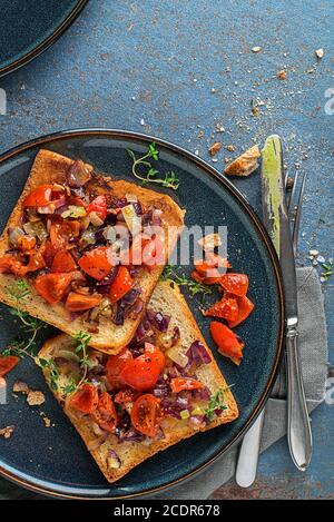 Vegetarian snack appetizer with tomatoes and onion on roasted bread , top view. Healthy food concept. Stock Photo