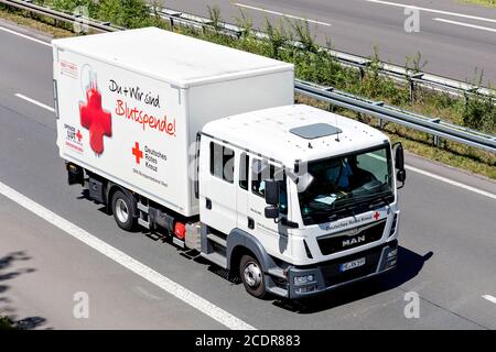 German Red MAN TGL truck on motorway. The German Red Cross, or the DRK, is the national Red Cross Society in Germany. Stock Photo