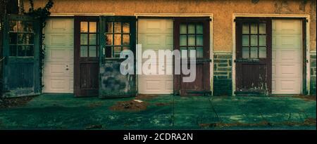 An Old-Fashioned Three Door Garage With a White Facade and Windows on Each Door Stock Photo
