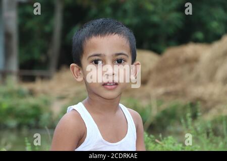 3 years old asian boy child standing beside a pond and looking at the camera Stock Photo