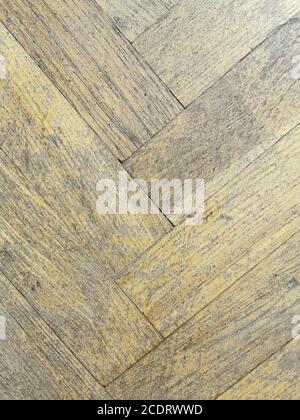 Background old dilapidated wooden parquet floor herringbone pattern. Stock Photo