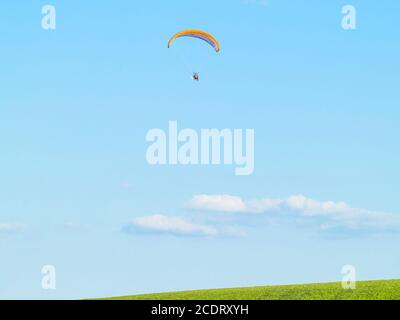 A man practicing extreme sport with paraglider with motor Stock Photo