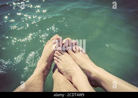 A couple in love wetting their feet in the sea. Summer holidays. Vintage. Stock Photo